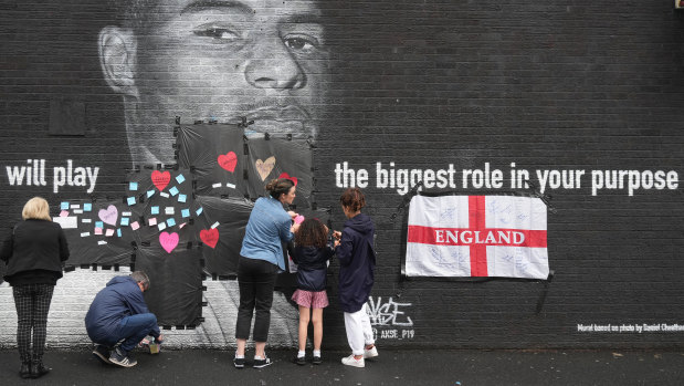 Residents put messages of support over racially-charged graffiti on a Marcus Rashford mural in Manchester.