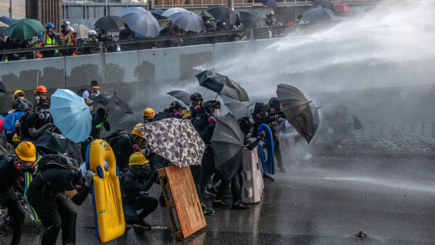 Pro-democracy protesters are hit by a water cannon during clashes at the Central Government Offices in Hong Kong, China. 