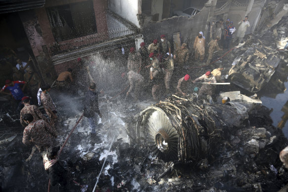 Rescue workers and local residents search for survivors in the wreckage of the crash that killed nearly 100 people.