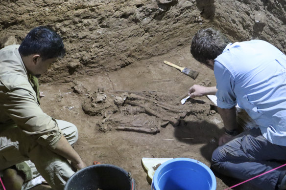 Dr Tim Maloney (right) and Andika Priyatno work at the site in a cave in East Kalimantan, Borneo, in 2020. The remains, which have been dated to 31,000 years old, mark the oldest evidence for amputation yet discovered.