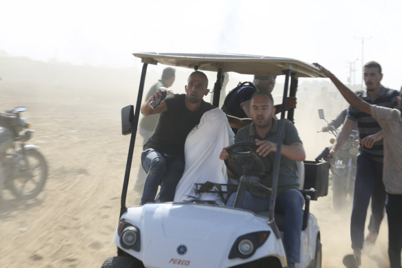 Palestinians transport a captured Israeli civilian from Kfar Azza kibbutz into the Gaza Strip.