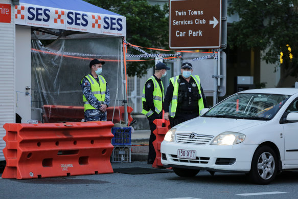 Police and defence personnel check on cars crossing the border at Coolangatta.