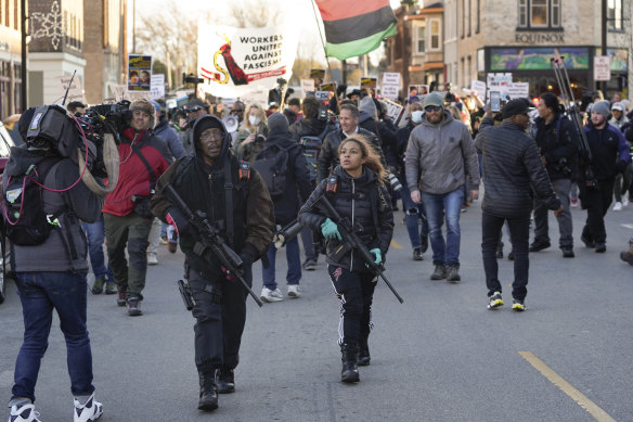 Erick Jordan and his daughter Jade, 16, carry rifles ahead of protesters marching in Kenosha, Wisconsin. 