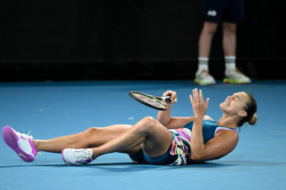 Aryna Sabalenka falls to the court after completing the come-from-behind win.