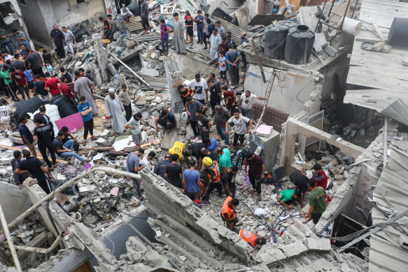 People search buildings destroyed during Israeli airstrikes in the southern Gaza Strip.