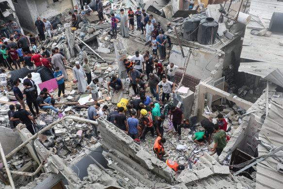 People search through buildings that were destroyed during Israeli air raids in the southern Gaza Strip.