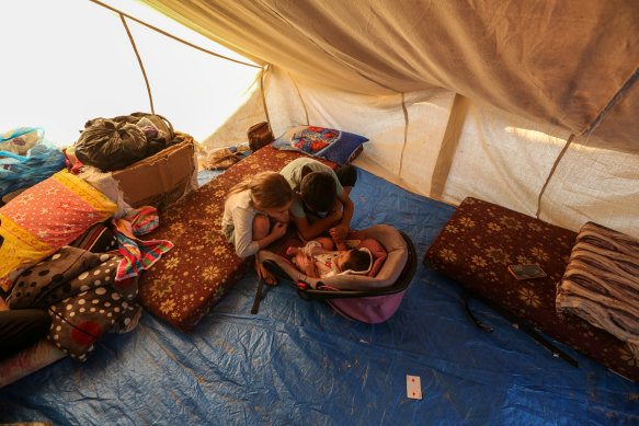 Children play with a baby in the refugee camp.