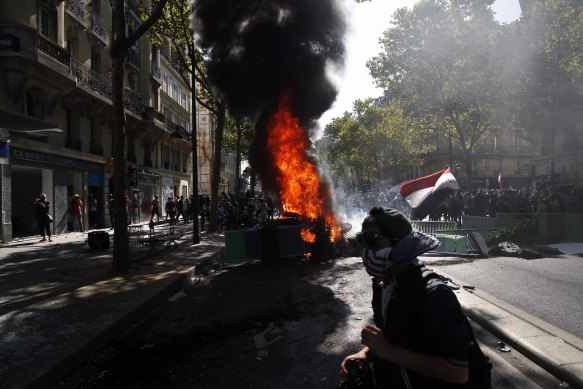 A protester walks past a burning barricade in Paris on Saturday.