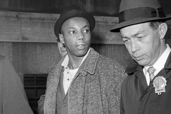 Norman 3X Butler, 26, a suspect in the slaying of Malcolm X, is escorted by detectives at police headquarters, after his arrest in 1965. 