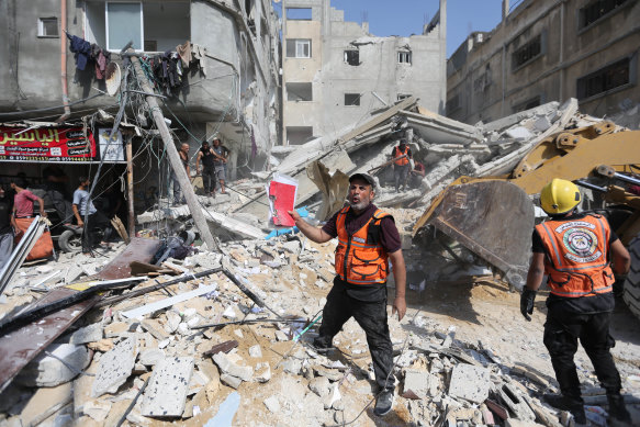 Palestinian emergency services and local citizens search for victims in buildings destroyed during Israeli air raids in the southern Gaza Strip.