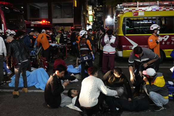 Rescue workers and firefighters try to help injured people.