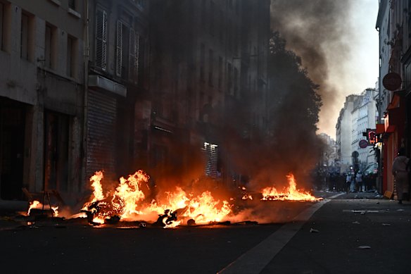 Fires burn in the street in central Paris on Sunday. 