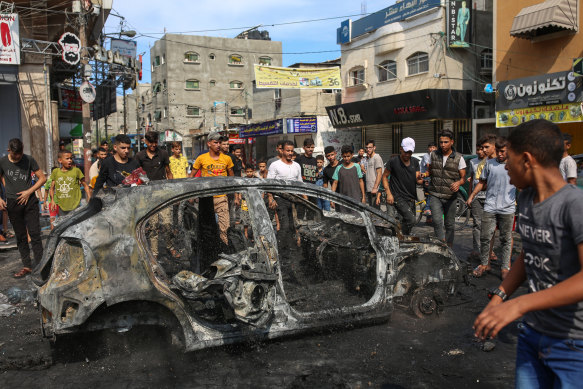 Young Palestinians chant and celebrate atop a car that was burned after being taken from Israeli territory and brought back to Gaza.