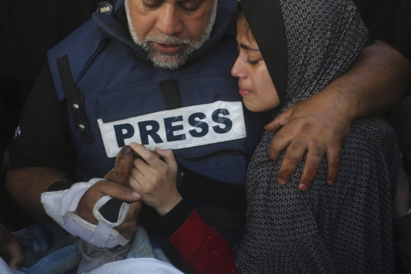 Al Jazeera journalist Wael Dahdouh holds the hand of his son Hamza, who also worked for Al Jazeera and who was killed in an Israeli airstrike in Rafah, Gaza Strip.