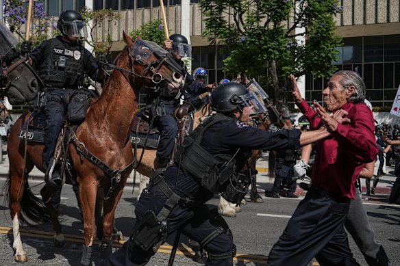 An LAPD officer pushes an elderly man during No Kings Day protests in June that followed ICE raids.