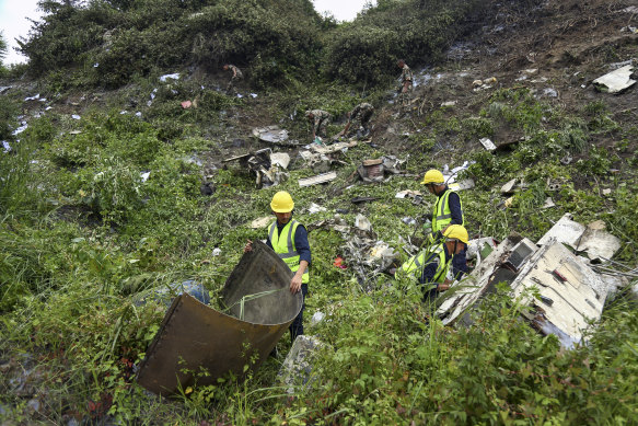 Rescuers search a plane crash site at Tribhuvan International Airport in Kathmandu.