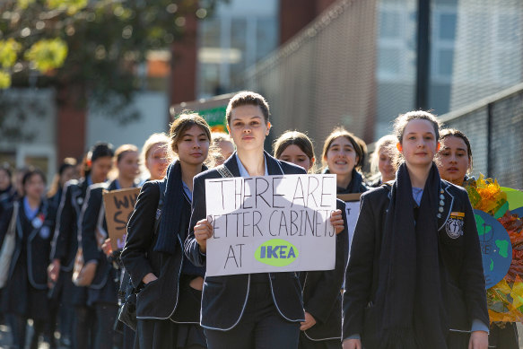 Camberwell Girls Grammar School year 11 student Charli Lincke (holding sign) and year 12 student Holly Williams lead classmates into the city for the rally on Friday.