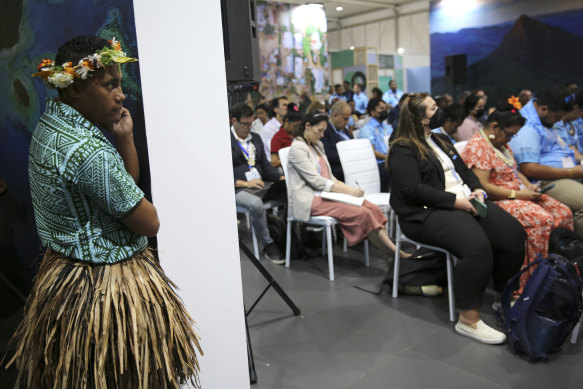 A dancer from the Tuvalu Youth Dance Troupe looks from the doorway after performing at the opening of a COP27 panel discussion on climate security in the Pacific.