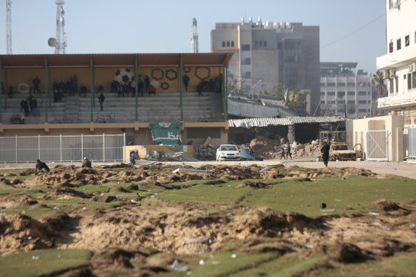 Palestinians gather at the badly damaged Yarmouk Stadium in Gaza to access the internet.