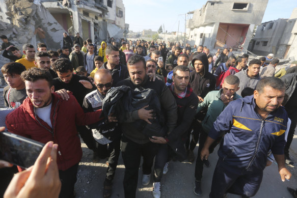 A Palestinian carries a relative killed in the Israeli bombardment of the Gaza Strip in Rafah.