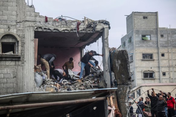 Palestinian citizens carry out search and rescue operations in the destruction caused by Israeli air strikes in Khan Younis, Gaza. 