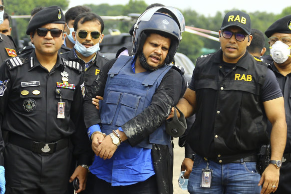 Mohammed Shahed, centre, the owner of two hospitals that issued thousands of fake coronavirus test reports, after being arrested in Dhaka, Bangladesh.