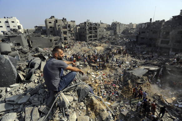 A man sits on the rubble overlooking the debris of buildings that were targeted by Israeli airstrikes in the Jabalia refugee camp, northern Gaza Strip.