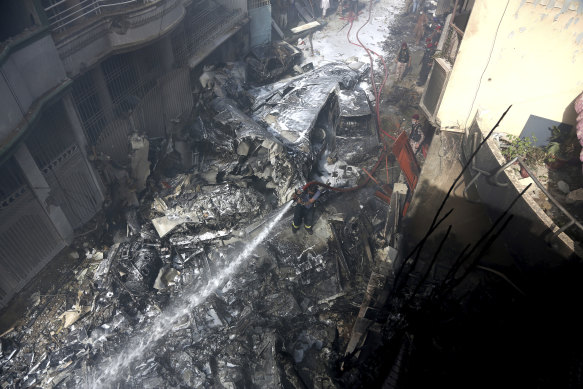 Fire brigade staff try to put out fire caused by plane crash in Karachi, Pakistan, on Friday.