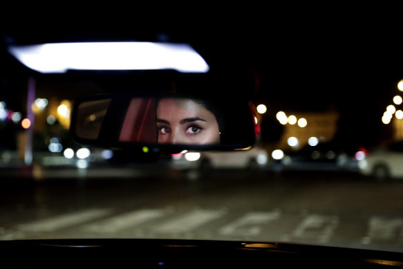 Hessah al-Ajaji drives her car down Riyadh busy Tahlia Street after midnight for the first time in June.