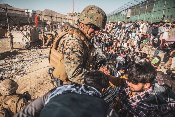 A US marine assists at an evacuation control check point during an evacuation at Hamid Karzai International Airport in Kabul, Afghanistan.