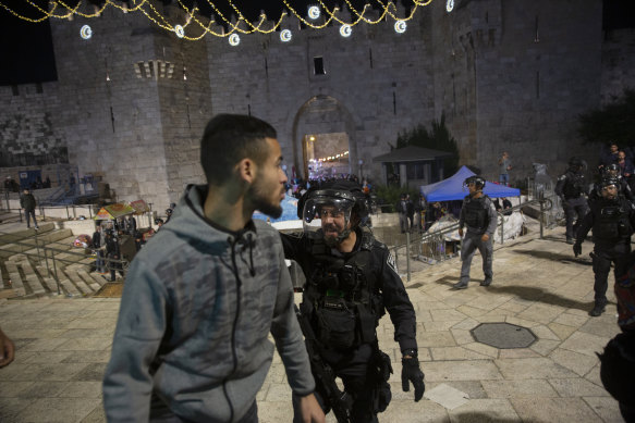 An Israeli policeman shouts at a Palestinian to move after clashes at the al-Aqsa Mosque compound on Friday.