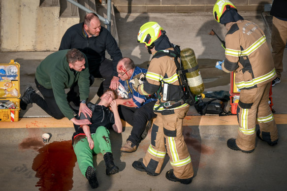 Firefighters provide assistance to officers playing the role of civilian casualties during the counterterrorism exercise. 