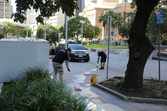 A cleaning crew at one of two CBD crime scenes set up after the fatal stabbing.