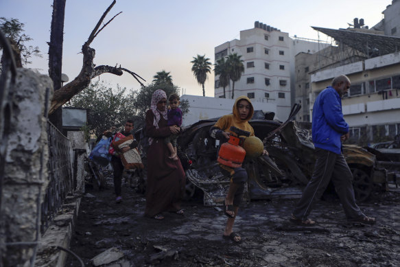 After the blast, Palestinians carry belongings as they leave AL Ahli Arab hospital, which they were using as a shelter.