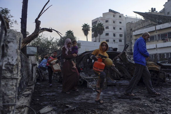 After the blast, Palestinians carry belongings as they leave Al Ahli Arab hospital where they were sheltering.