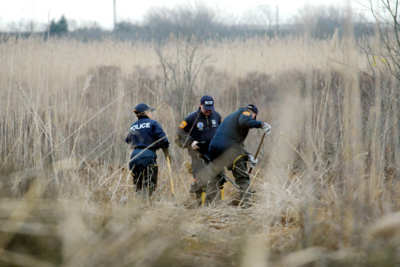 Crime scene investigators use metal detectors to search a marsh for the remains of Shannan Gilbert on December 12, 2011 in Oak Beach, New York. 