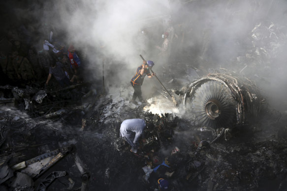 Volunteers look for survivors after a plane crashed into a residential area of Karachi.