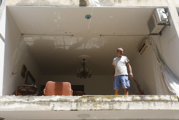 A man looks out from the collapsed facade of a building in downtown Beirut.