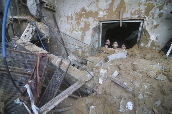 Palestinian children look at the building of the Zanon family, destroyed in Israeli airstrikes in Rafah, Gaza Strip.