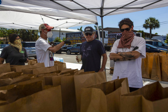 With more than 10 million people across the nation suddenly unemployed, volunteers are handing out food to bread lines forming in the shadows of privileged enclaves like this one in Florida.
