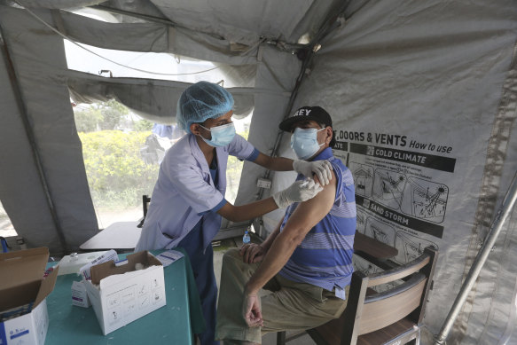 An elderly Nepalese man receives a COVID-19 vaccine in Kathmandu in 2021.