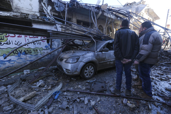 Residents survey the aftermath of airstrikes in Idlib on Saturday.
