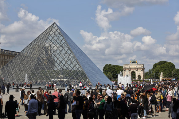 Tourists wait in line to visit the Louvre museum as it reopens in May.