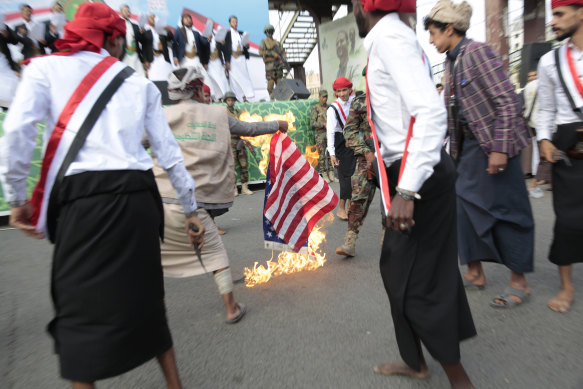 Husi destekçileri, Eylül 2021'de Yemen'in başkenti Sanaa'da Husilerin Yemen'in başkentini ele geçirmesinin yedinci yıldönümünü anmak için düzenlenen mitingde ABD bayrağının bir temsilini yaktılar.