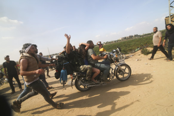 Palestinians transport a captured Israeli civilian from Kfar Azza kibbutz into the Gaza Strip.