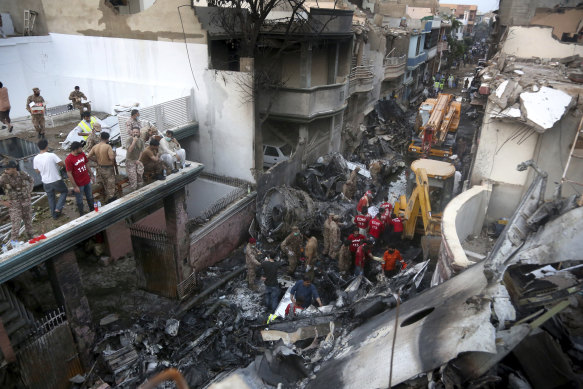 Volunteers and soldiers look for survivors of a plane crash in a residential area of Karachi, Pakistan.