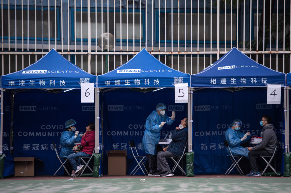 People receive COVID-19 PCR tests at a testing facility in the Tuen Mun area of Hong Kong.