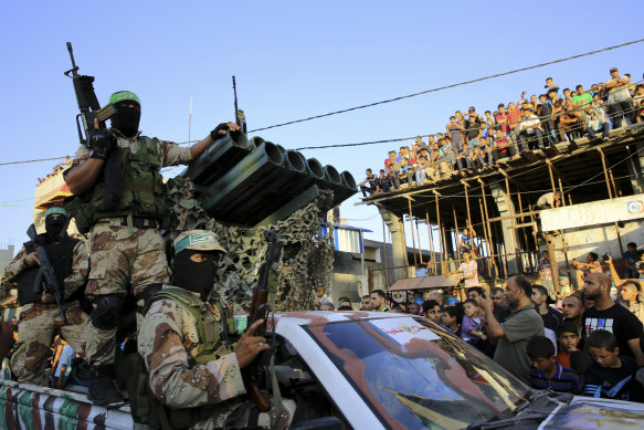 Palestinian masked members from the Izzedine al-Qassam Brigades, a military wing of Hamas, ride next to a rocket launcher during a rally in Rafah refugee camp, Gaza Strip, in 2016.