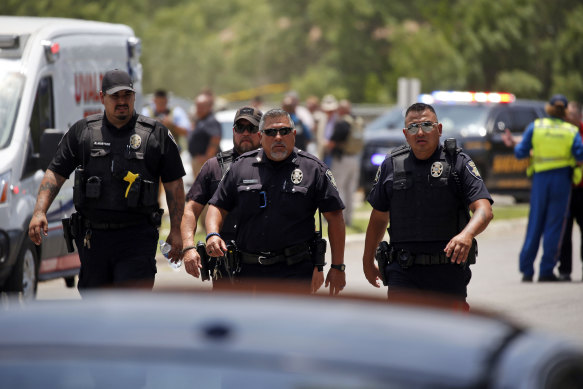 Police walk near Robb Elementary School following the shooting.