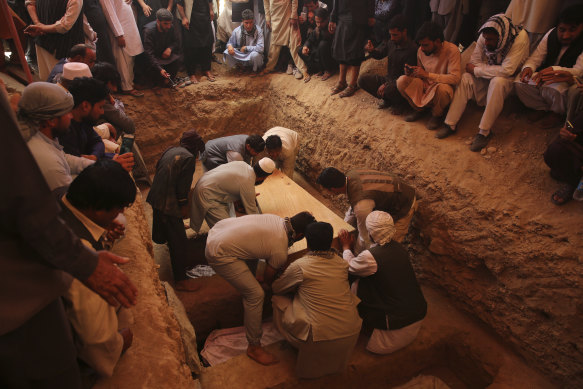 Families and friends bury the victims of the Dubai City wedding hall bombing during a mass funeral in Kabul on Sunday.